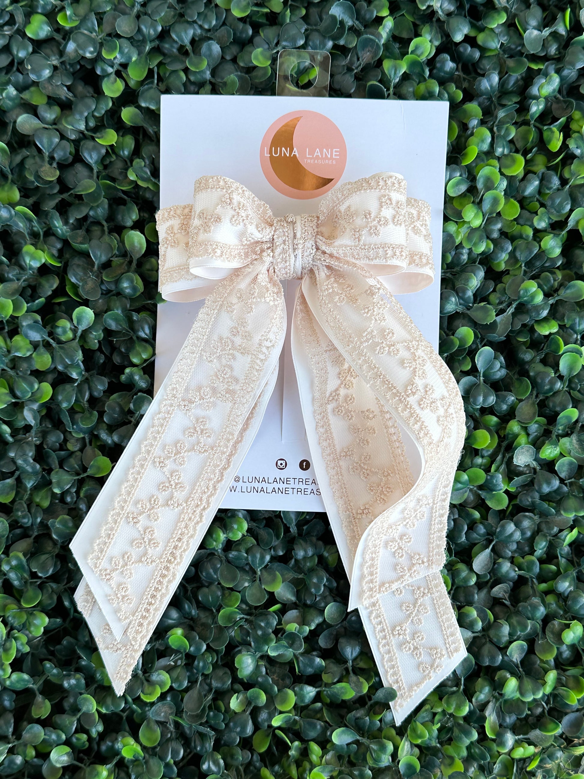 Enhance your hairstyle with the tan Coquette Hair Bow. This 5 inch wide and 8 inch long hair bow is made with delicate lace and satin matte ribbon for a sophisticated touch. Add a touch of elegance to any outfit with this stylish hair accessory.     comes attached to a French Barrett