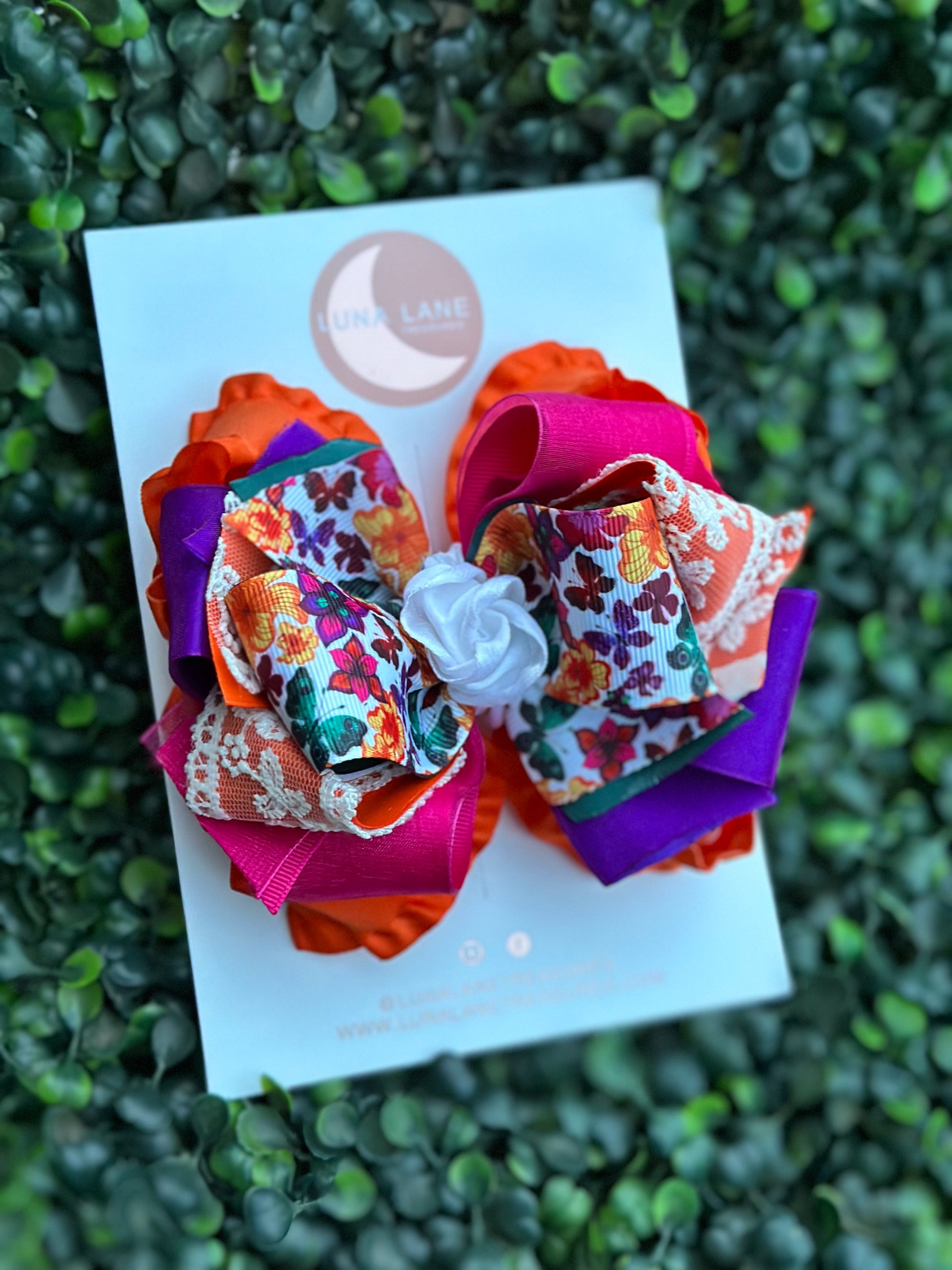 Add a touch of whimsy to any hairstyle with the Fiesta Butterflies Ruffle Hair Bow Casual. This 4-inch wide hair bow is made from a combination of ruffle, grosgrain, satin, and sheer ribbons for a truly unique look.