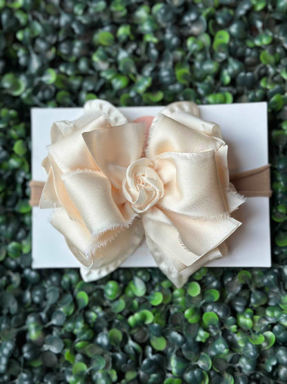 Ivory Satin Chiffon Ruffle Bow, Double Ruffle Ribbon: The bow features layers of double ruffle ribbon, which adds volume and texture to your hairstyle. Satin Chiffon: Made with high-quality satin chiffon, the bow has a soft and smooth texture that looks great on any hair type. Easy to Use: The Ivory Satin Chiffon Ruffle Hair Bow comes attached with an alligator clip, making it easy for you to style it in different ways as per your preference.