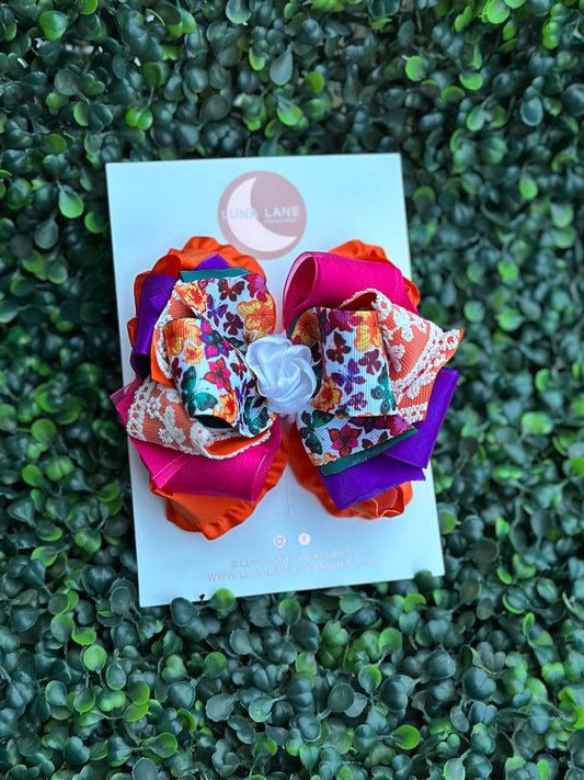 Add a touch of whimsy to any hairstyle with the Fiesta Butterflies Ruffle Hair Bow Casual. This 4-inch wide hair bow is made from a combination of ruffle, grosgrain, satin, and sheer ribbons for a truly unique look.